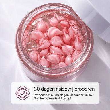 Close-up van roze capsules in de PDRN Niacinamide Crème met 30 dagen risicovrij proberen